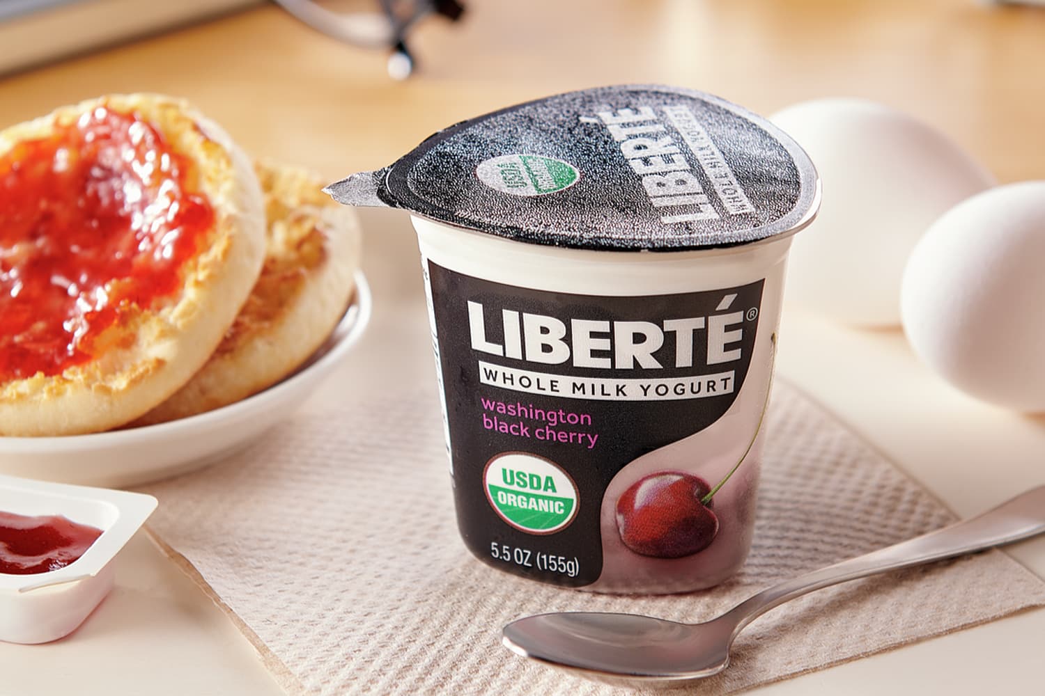 A package of Liberte yogurt surrounded by toast, eggs and jam